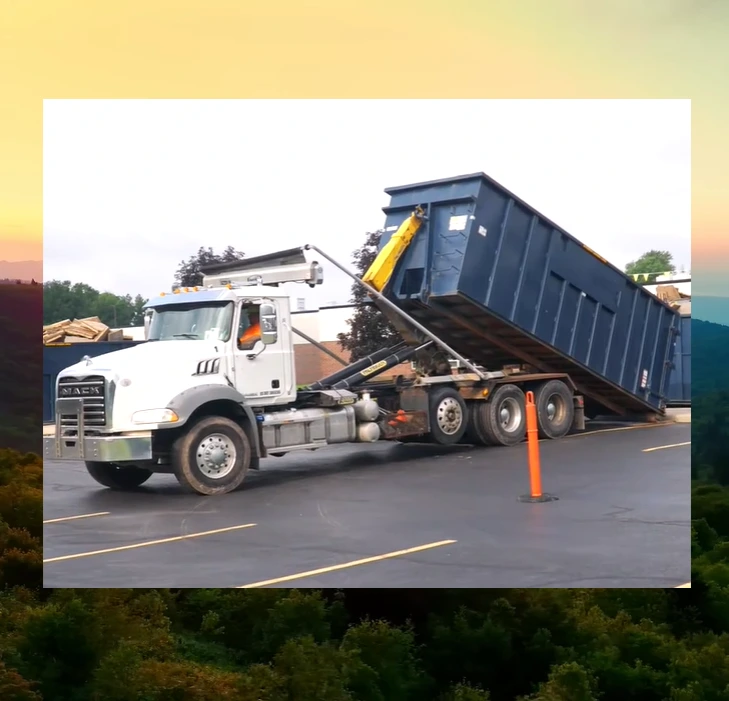 Dumpster delivery truck positioning a roll-off container
